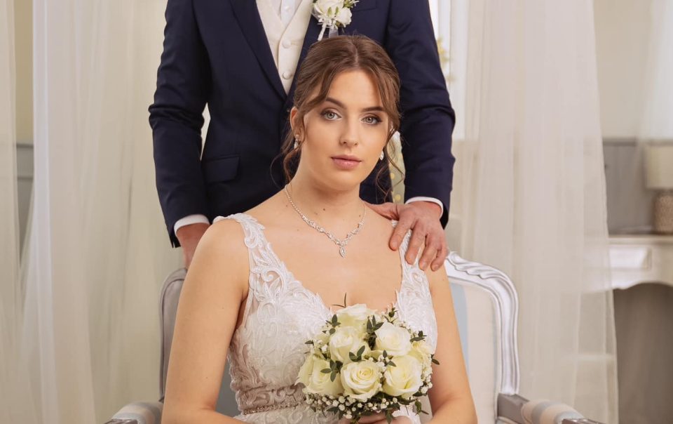 Esküvői fotó- és videózás – pár ül és áll kombinált pózban, elegáns enteriőrben